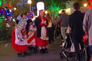 ladies hand out christmas ornaments at magic kingdom